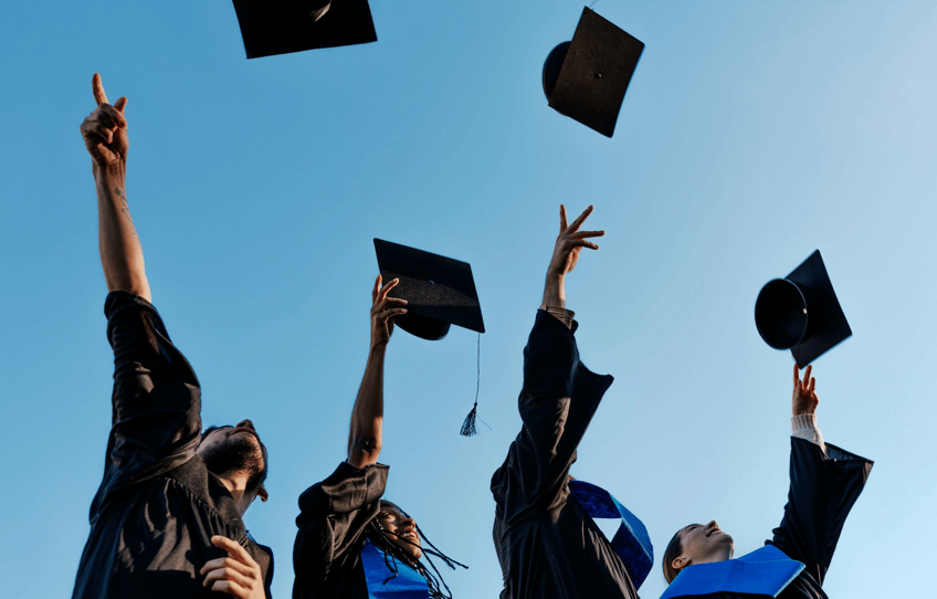 studenter som kastar mössor mot himlen