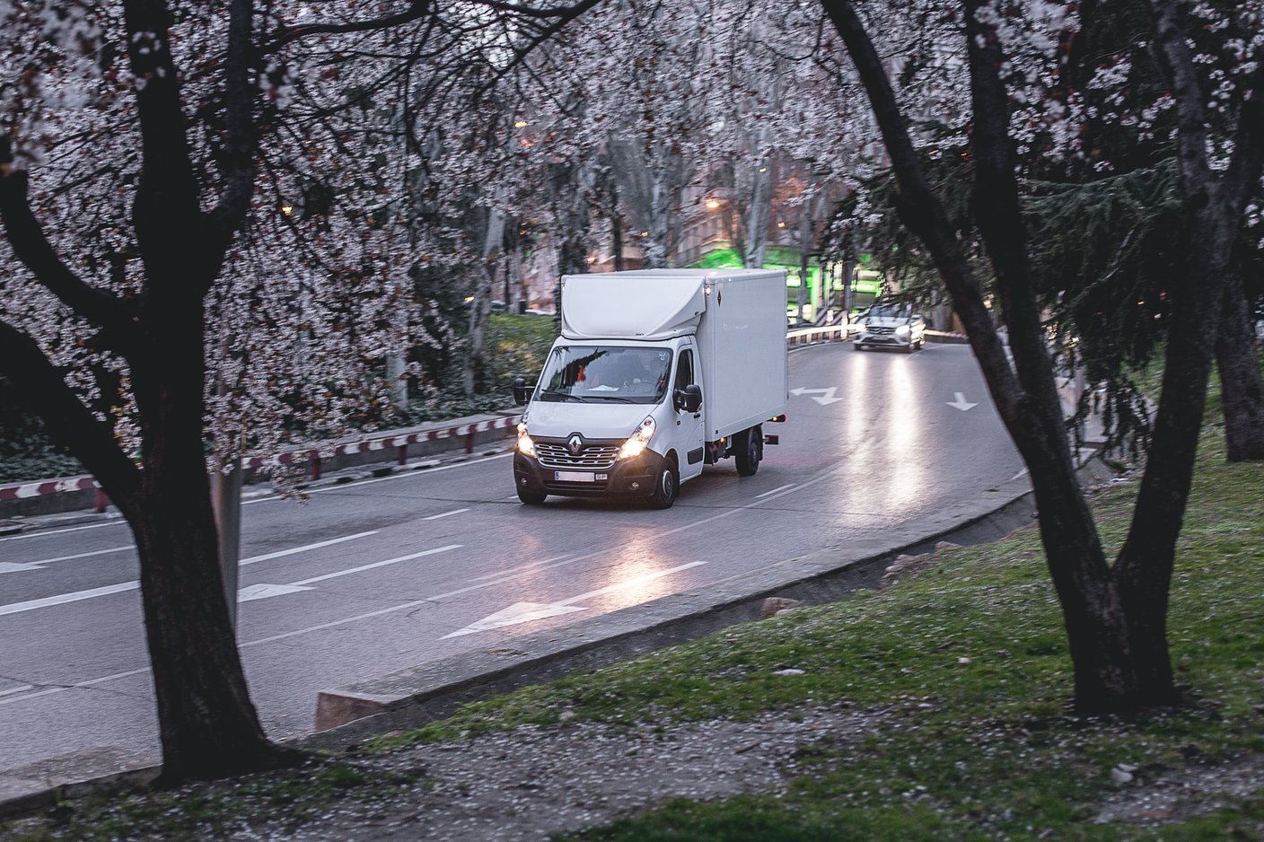 vit lastbil som kör på väg