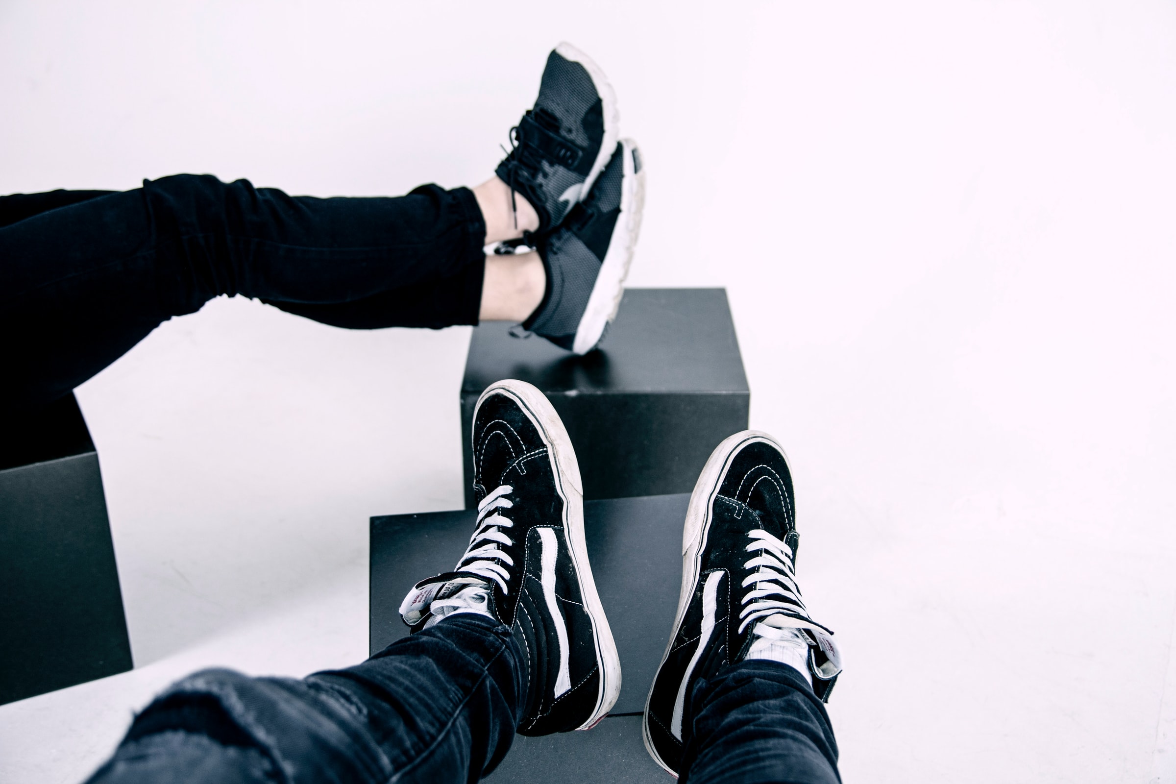 två olika par svarta sneakers